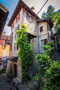 a large stone building with plants growing around it at Il mulino in Varenna