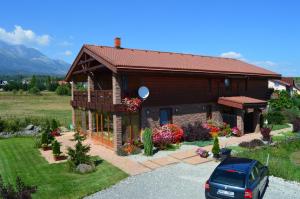 a house with a car parked in front of it at Penzion Tri klasy in Nová Lesná