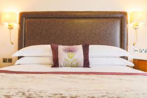 a bedroom with a large bed with a large headboard at Swan's Nest Hotel in Stratford-upon-Avon