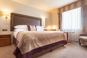 um quarto de hotel com uma cama grande e uma janela em Swan's Nest Hotel em Stratford-upon-Avon
