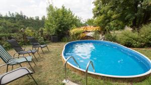 a swimming pool in the yard with chairs at Penzion Ctrnactka in Rataje nad Sázavou