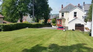 a yard with a large lawn in front of a house at Ty Castell Guest House in Caerphilly
