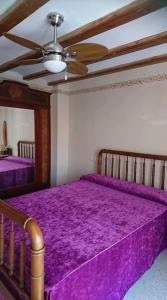 1 dormitorio con cama morada y ventilador de techo en Vivienda Vacacional Ca Pep, en Benimantell