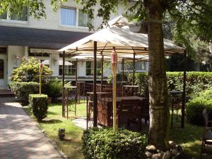 een tafel en stoelen onder een paraplu in een tuin bij Hotel am Stadion in Duisburg