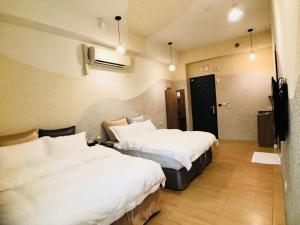 a hotel room with two beds and a television at Bi Xuelin in Lugu
