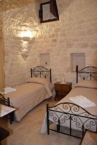 a bedroom with two beds and a clock on the wall at Dimora Domrose in Locorotondo