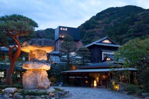 ein Resortgebäude mit einem Berg im Hintergrund in der Unterkunft Seiryu-so in Shimoda