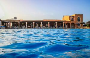 a pool with blue water in front of a building at Colina Village in Carvoeiro