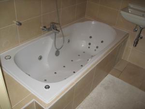 a white bath tub in a bathroom with a sink at Nori TV in Ostend