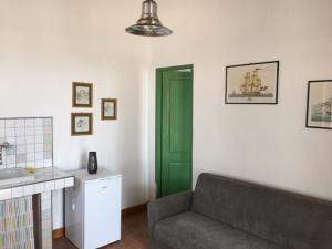 CROTIN 1897 في Roatto: غرفة معيشة مع أريكة وباب أخضر