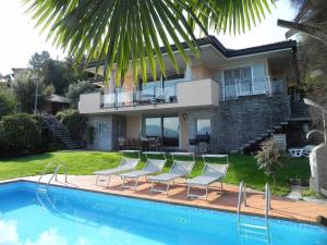 a house with a swimming pool with chairs and a house at Villa Diamante in Meina
