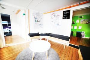 Tromso Activities Hostel في ترومسو: غرفة معيشة مع أريكة سوداء وطاولة بيضاء