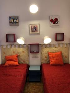 トレモリノスにあるArtas Apartamentosのオレンジ枕付きのベッド2台が備わる客室です。