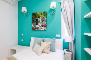 a blue bedroom with a white bed and a window at Apartamento Smile Sol in Madrid