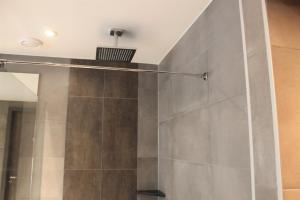 La salle de bains est pourvue d'une douche avec une porte en verre. dans l'établissement Dream Hotel Amsterdam, à Amsterdam