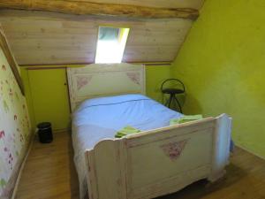 a small bedroom with a white bed with a window at Lalot in Oulches