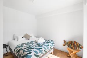 1 dormitorio con 1 cama y 1 silla en Le Ponant by Cocoonr, en Dinard
