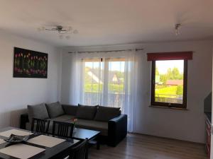a living room with a couch and a table at Apartament Emilia in Karwia