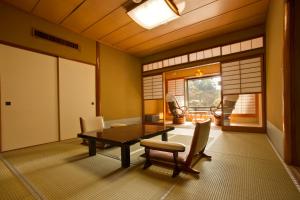 a dining room with a wooden table and chairs at Seiryu-so in Shimoda