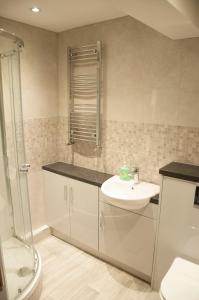 a bathroom with a sink and a shower at The Square Guest Apartment in Stewartstown