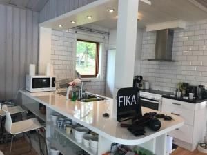 a kitchen with a counter with a sink and a microwave at Galasjön 132 in Mellansel