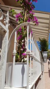 a white railing with purple flowers on a house at Monolocale II La Maddalena in La Maddalena +2 photos