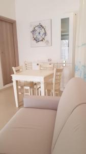 a white dining room with a white table and chairs at Monolocale II La Maddalena in La Maddalena