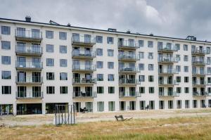 een groot wit appartementencomplex met balkons bij FeWo Prora - Hygge in Binz