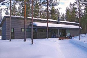 uma casa na neve com árvores cobertas de neve em Harjunranta em Kuusamo