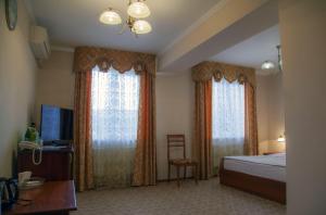 a hotel room with a bed and two windows at Respect in Stavropol