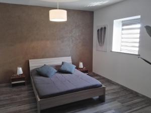 um quarto com uma cama com almofadas azuis e uma janela em Beaux lofts près d'Europa Park et Strasbourg em Obenheim