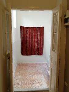 a red curtain in a white room with a window at The Grand Meshmosh Hotel in Beirut
