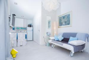 a white room with a blue couch and a kitchen at Casa Blanca White House in Okrug Donji