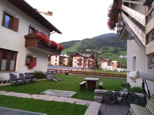 um pátio de um edifício com uma mesa e bancos em Casa dello Sciatore em Bormio