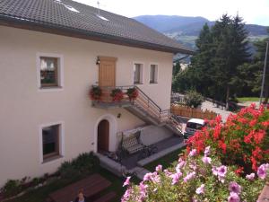 una casa con un banco y flores en el balcón en Casa dello Sciatore, en Bormio