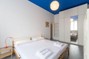 una camera da letto con un grande letto bianco e un soffitto blu di Hbhall Residenze Darsena a Milano