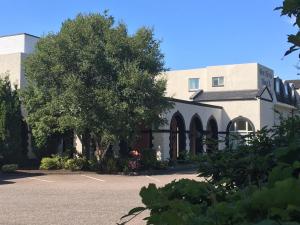 a building with a tree in a parking lot at Ben Nevis Hotel & Leisure Club in Fort William
