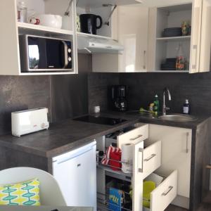 a kitchen with white cabinets and a sink at Studio Hesperides in Balaruc-les-Bains