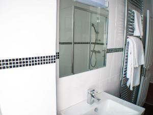a white bathroom with a sink and a mirror at Mereside in Douglas