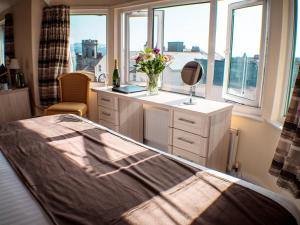 a bedroom with a bed and a window at Mereside in Douglas