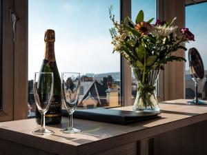 a bottle of champagne and glasses on a table with a window at Mereside in Douglas