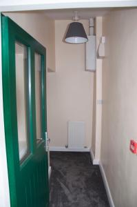 une porte verte dans une chambre avec couloir dans l'établissement The Stables Guest Apartment, à Cookstown