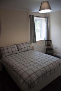 
a bed room with a white bedspread and pillows at The Stables Guest Apartment in Cookstown

