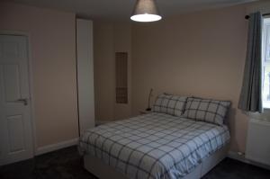 
a bedroom with a bed and a lamp at The Stables Guest Apartment in Cookstown

