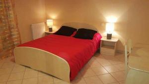 a bedroom with a large bed with red sheets and two tables at Nina in Carcassonne