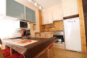 a kitchen with a counter with a white refrigerator at Julia, el Tarter, zona Grandvalira in El Tarter