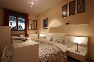 a bedroom with a bed with a desk and a window at Julia, el Tarter, zona Grandvalira in El Tarter