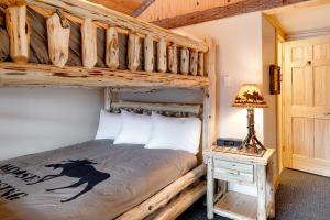 a bedroom with a bunk bed and a table with a lamp at Cobble Mountain Lodge in Lake Placid