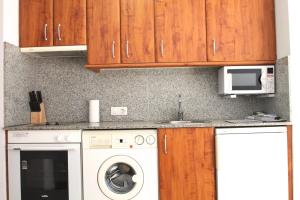 a kitchen with a washing machine and a microwave at Genciana Estudio en el Tarter, zona Grandvalira in El Tarter