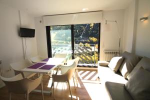 a living room with a couch and a table and chairs at Genciana Estudio en el Tarter, zona Grandvalira in El Tarter